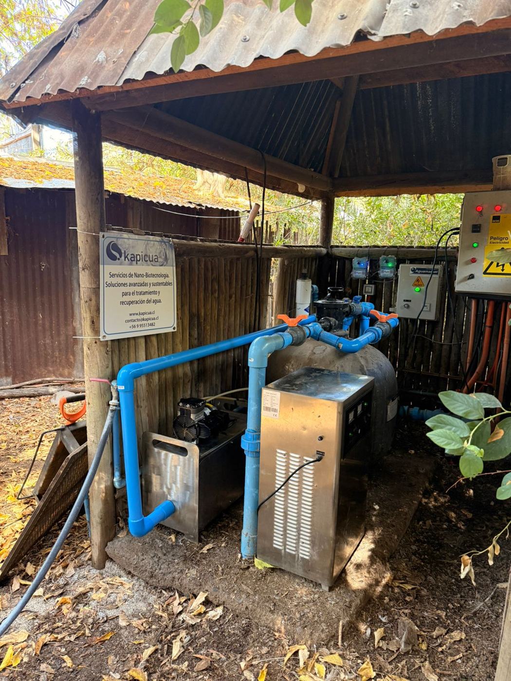 Instalación de tratamiento de agua Kapicua en terreno agrícola, con señalética de marca